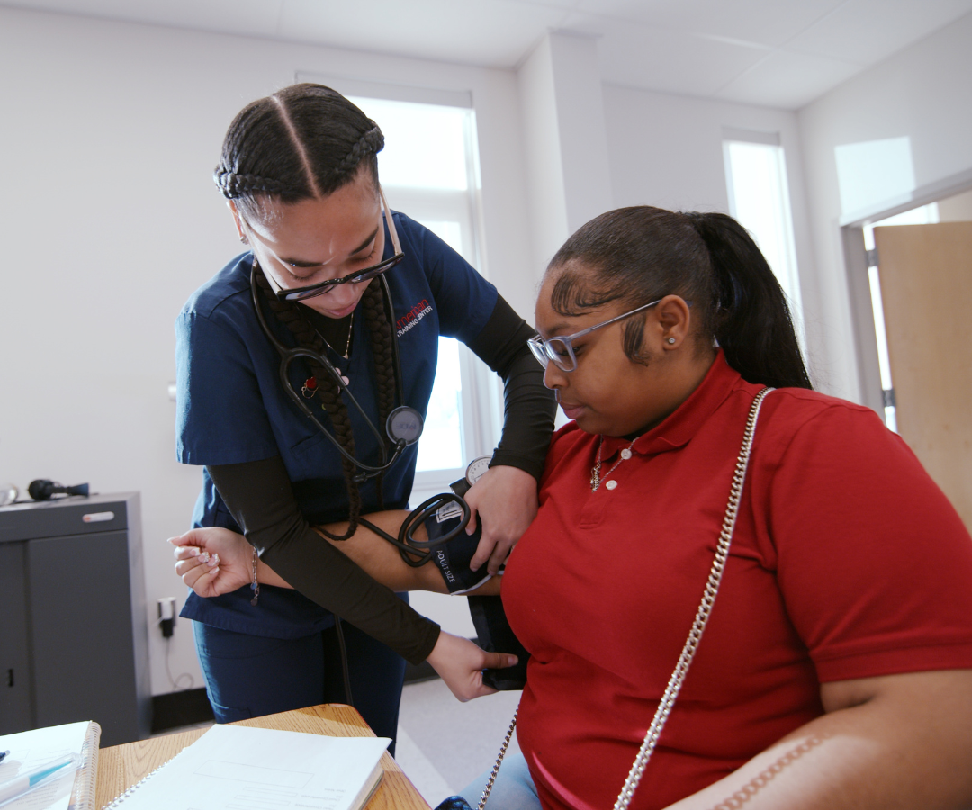 female student with another student in healthcare classroom